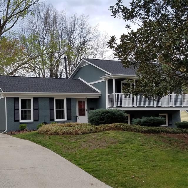 Blue house with a driveway and front lawn