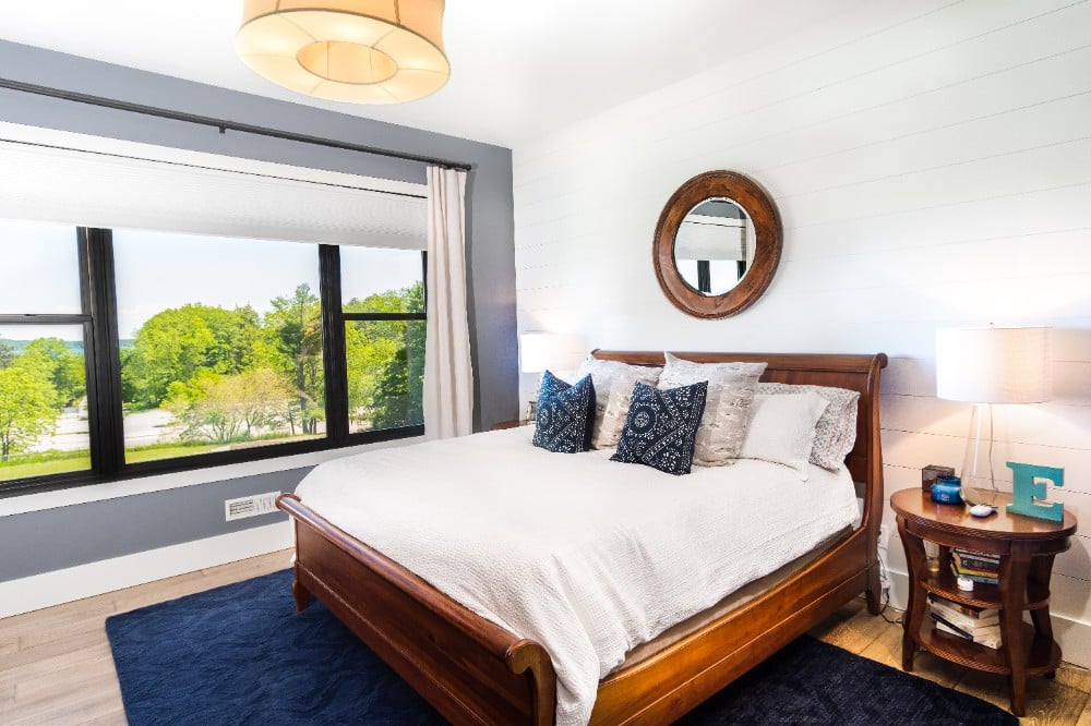 Serene bedroom ambiance with pristine painted white wood panel walls complemented by a stylish gray accent wall, highlighting the refined craftsmanship of our residential painting services in Cranberry, PA.