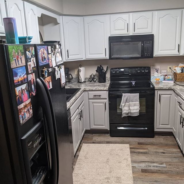 White kitchen cabinets with black appliances