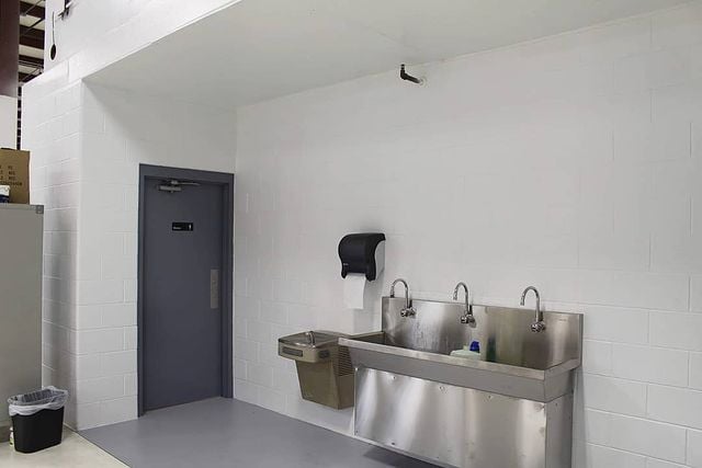 white walls with gray door and sink
