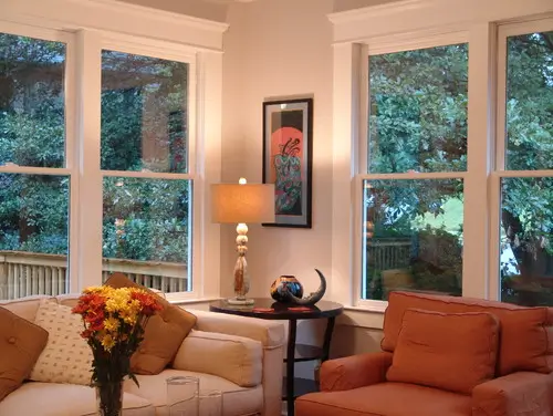 Couches in a living room in front of four windows.