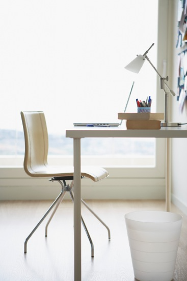 Minimalist office that is light and bright with a large window.