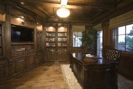 Traditional home office with wooden desk and bookshelves.