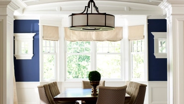 Dining room with wooden floors viewed through an archway.
