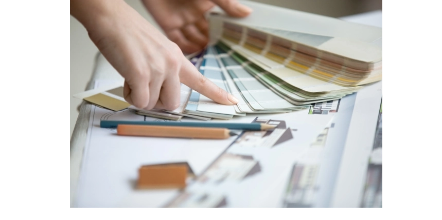 Closeup of a woman pointing to color on a color palette chart.