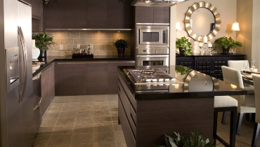 Photo of a darkly colored, large kitchen