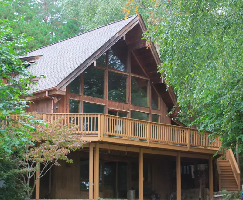 Photo of a wooden cabin surrounded by trees.