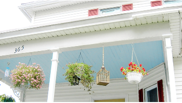 Photo of a porch ceiling painted sky blue on a two story house.