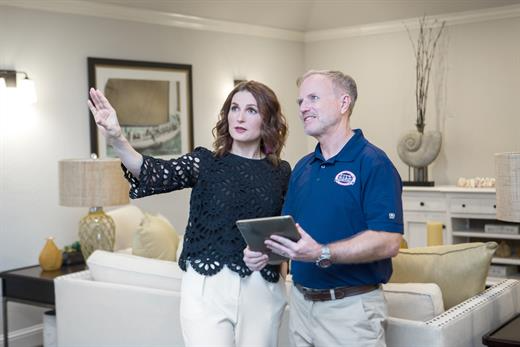 winter painting Five Star Painting technician talking to a woman in a living room
