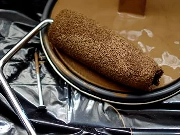 Paint roller in light brown paint.
