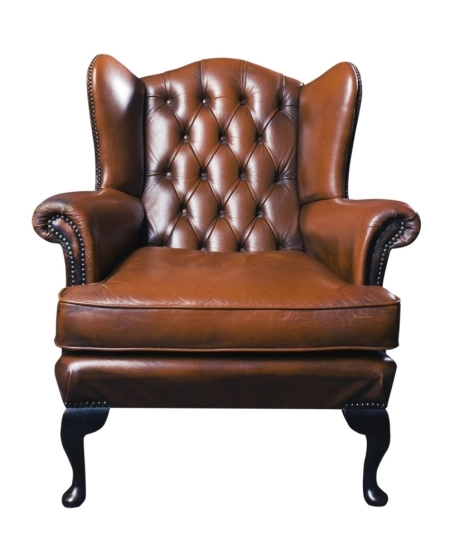 Brown leather wingback chair with tufted backrest and nailhead trim on white background.
