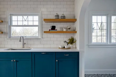 A modern kitchen with blue cabinets and white walls painted Five Star Painting in Ann Arbor, MI